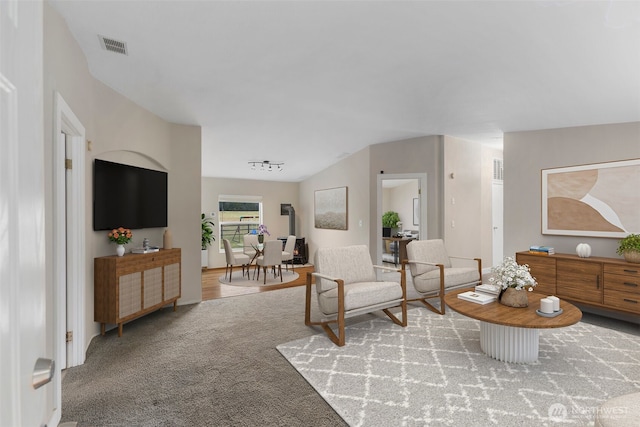 living area featuring visible vents and carpet floors