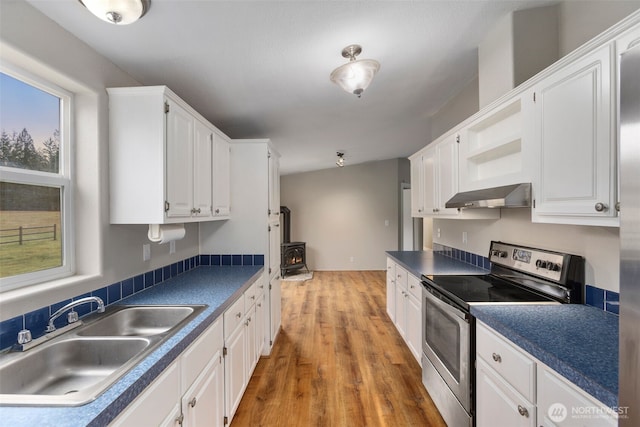 kitchen with range hood, stainless steel electric stove, a sink, white cabinetry, and dark countertops