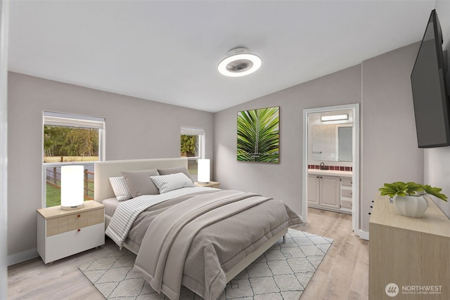 bedroom with baseboards, lofted ceiling, a sink, light wood-style floors, and ensuite bathroom