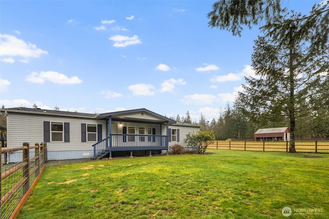 rear view of house featuring a yard and fence