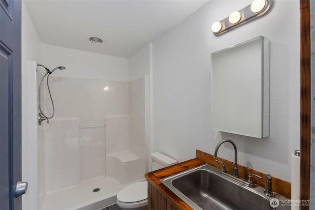 bathroom featuring toilet, walk in shower, and vanity