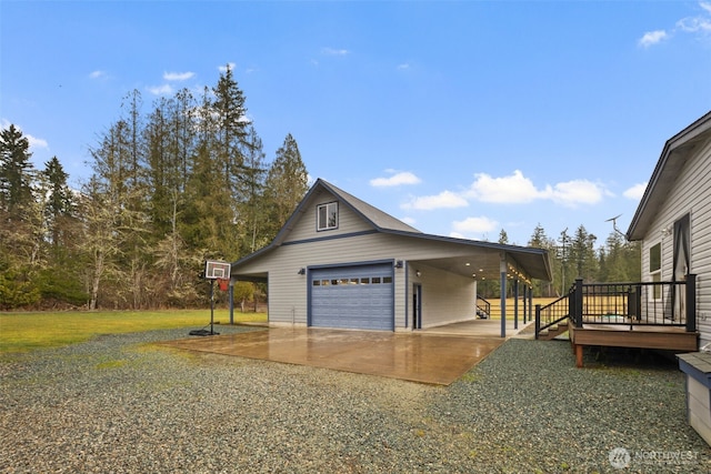 view of side of property with a garage, a lawn, and a wooden deck