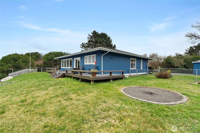 back of house with a fenced backyard, a lawn, and a deck