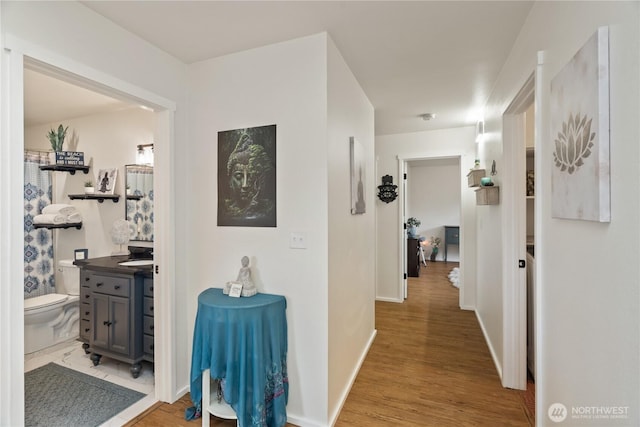 hall featuring wood finished floors and baseboards