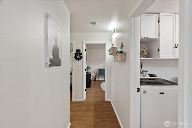 hallway with baseboards, washer / clothes dryer, and wood finished floors