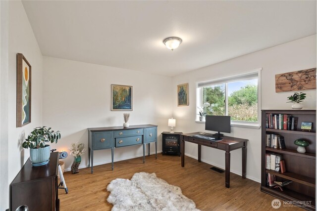 home office featuring wood finished floors and baseboards