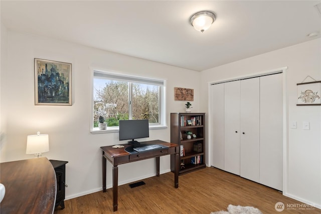 home office with visible vents, baseboards, and wood finished floors