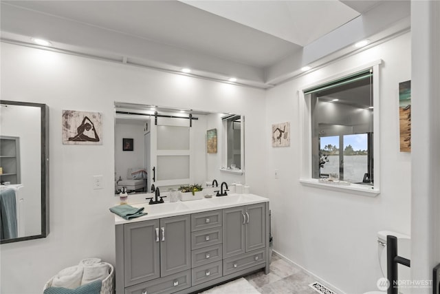 bathroom featuring a sink, toilet, and double vanity