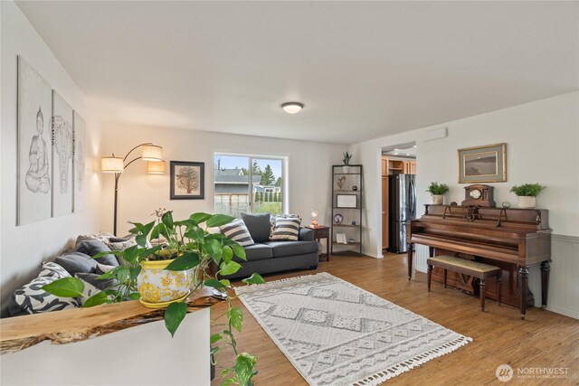 living area featuring wood finished floors and wainscoting