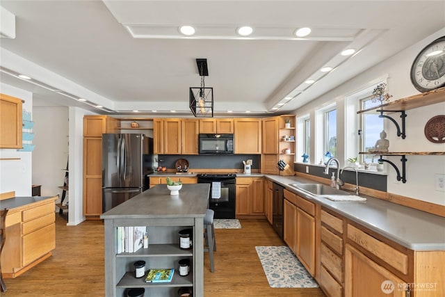 kitchen featuring black appliances, light wood-style flooring, open shelves, a sink, and a raised ceiling