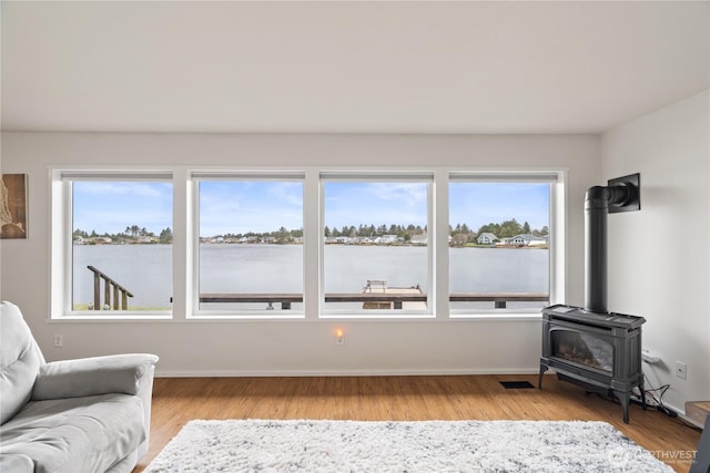 living area featuring a wealth of natural light, visible vents, and light wood-type flooring