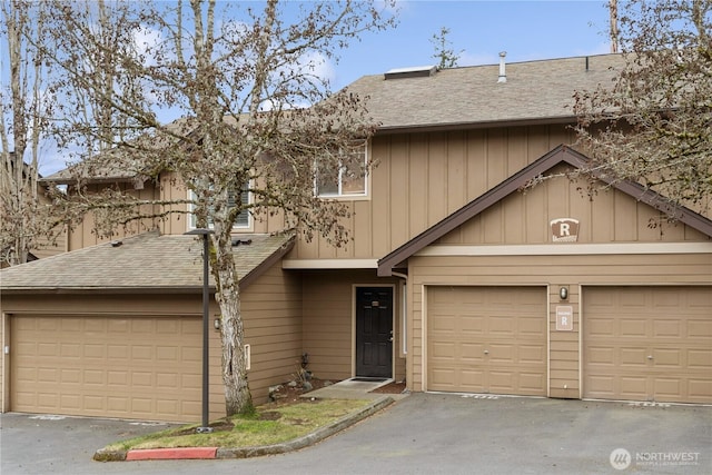 townhome / multi-family property featuring a garage and roof with shingles