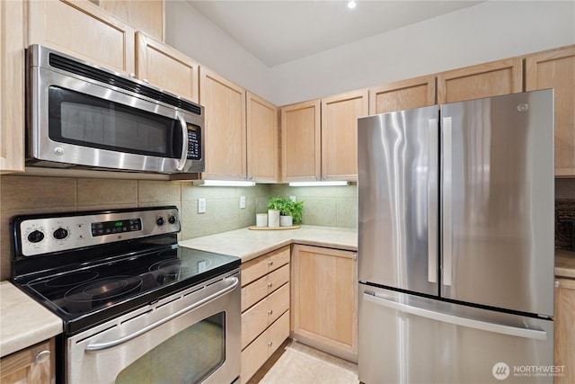 kitchen featuring light brown cabinets, appliances with stainless steel finishes, tasteful backsplash, and light countertops