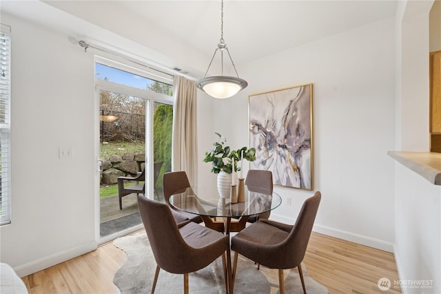 dining room with light wood-style floors and baseboards