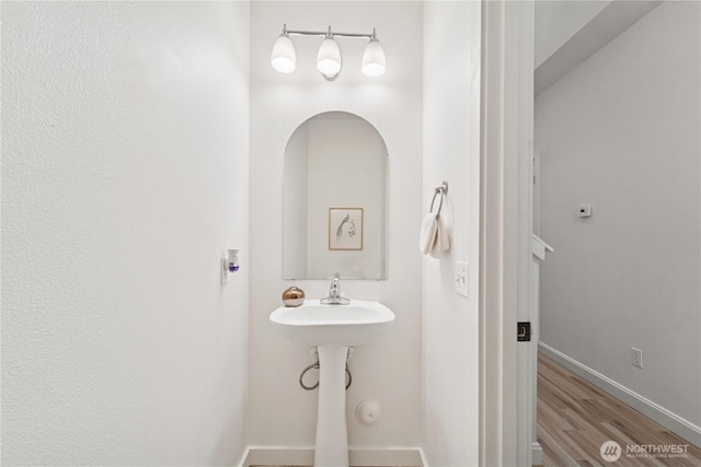 bathroom with baseboards and wood finished floors