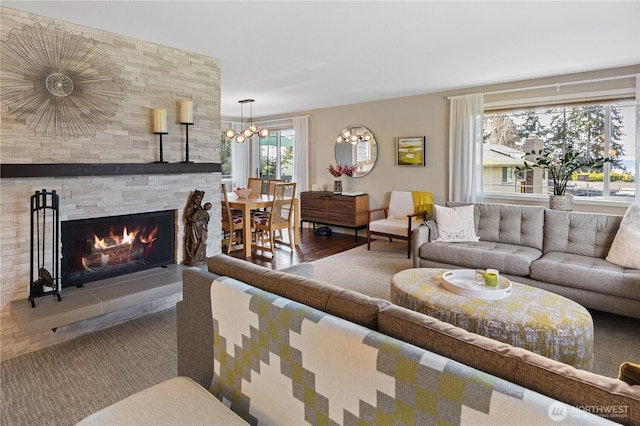 living room featuring a notable chandelier and a fireplace