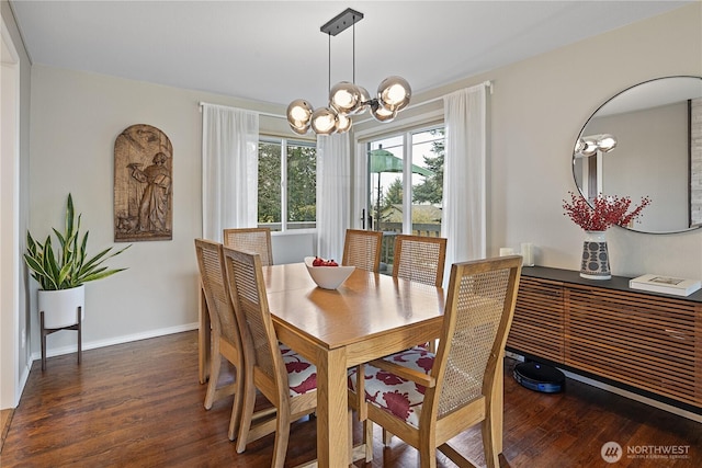 dining space featuring baseboards, a notable chandelier, and wood finished floors