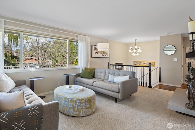 living room featuring a chandelier, baseboards, and wood finished floors