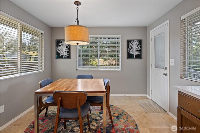 dining area with baseboards and light tile patterned flooring