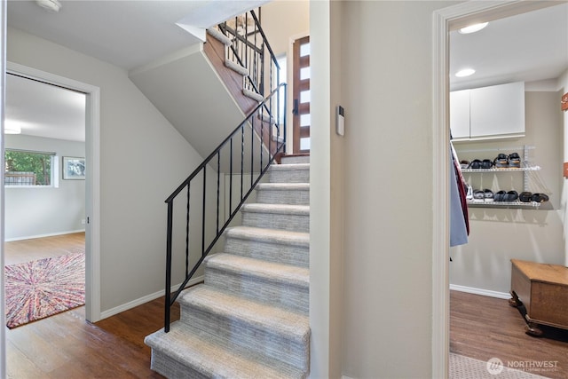 stairs with wood finished floors and baseboards