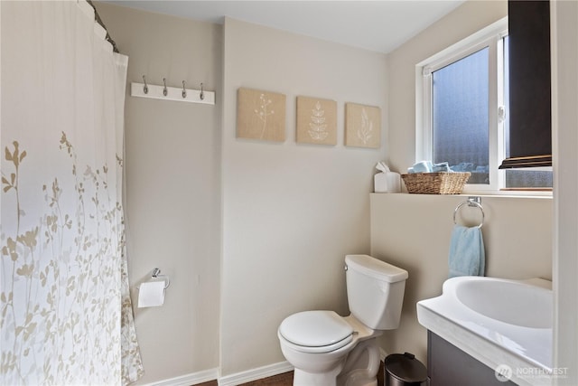 full bath featuring a shower with curtain, baseboards, toilet, and vanity