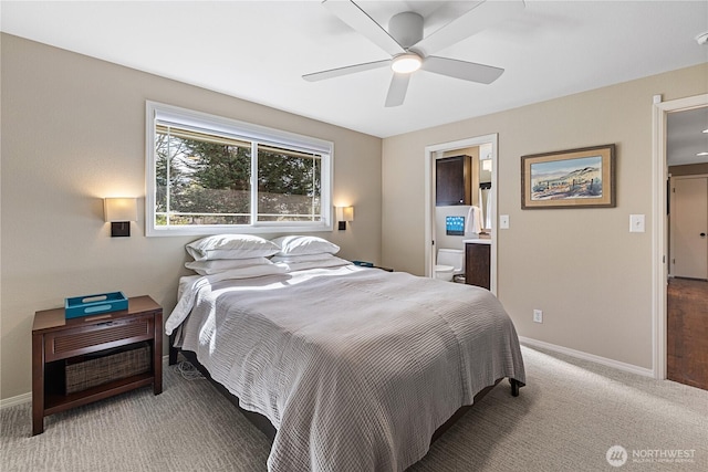 bedroom featuring light colored carpet, a ceiling fan, ensuite bathroom, and baseboards