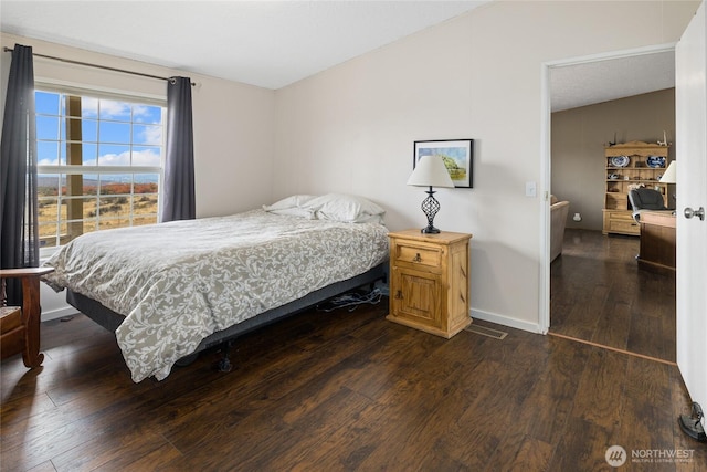 bedroom featuring dark wood-style floors and baseboards