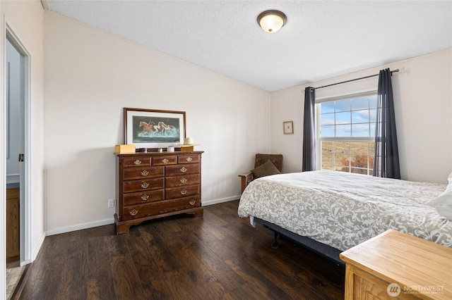 bedroom with dark wood-style floors, baseboards, and lofted ceiling