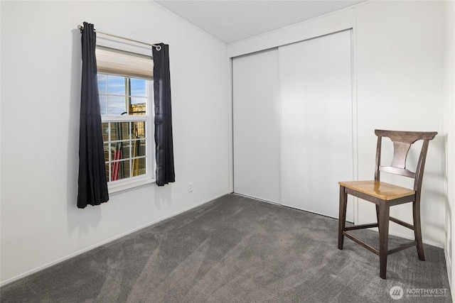 unfurnished room featuring lofted ceiling and dark colored carpet