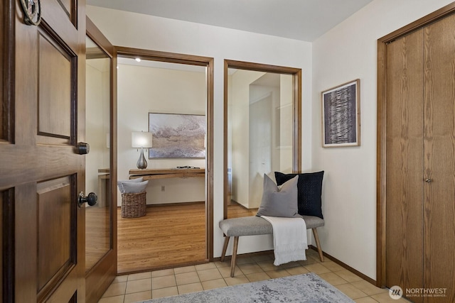 sitting room featuring light tile patterned floors and baseboards