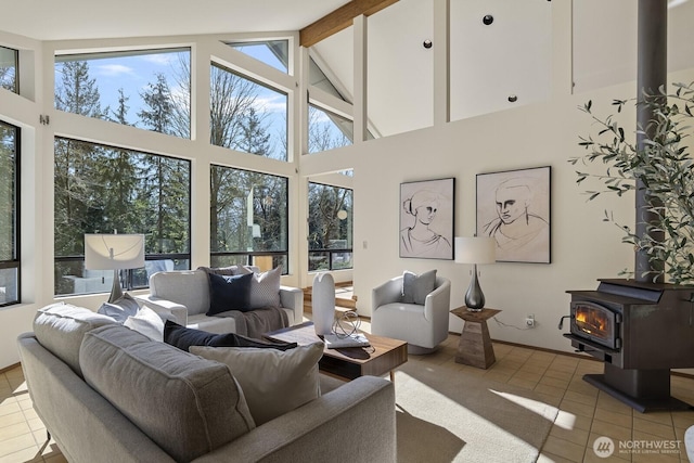 living room with tile patterned floors, beam ceiling, high vaulted ceiling, and a wood stove