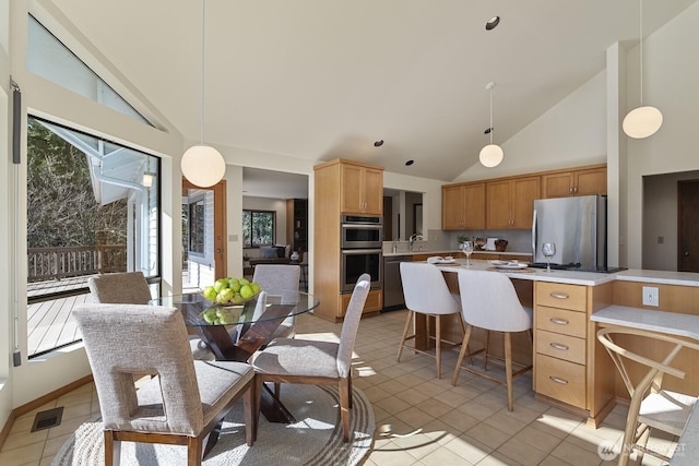 dining space with light tile patterned floors, baseboards, visible vents, and high vaulted ceiling