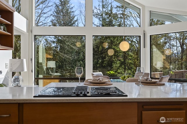 interior space featuring light stone counters, open shelves, and stovetop with downdraft