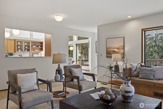 living area with light tile patterned floors, a healthy amount of sunlight, and visible vents