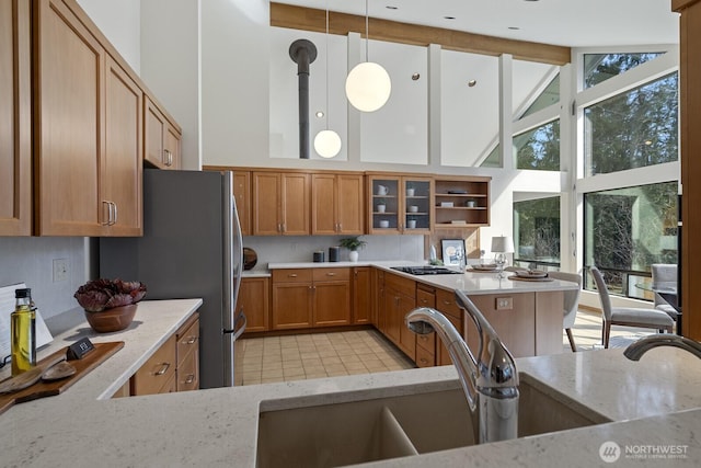 kitchen with light stone countertops, high vaulted ceiling, and brown cabinetry