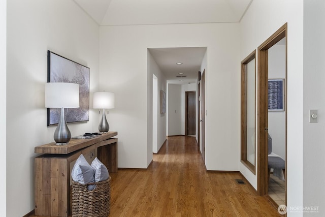 hall featuring visible vents and wood finished floors