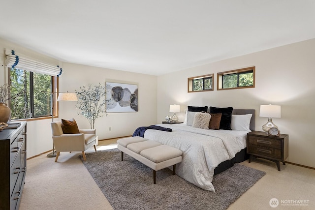 bedroom featuring light colored carpet and baseboards