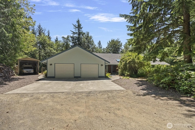 garage with a carport and driveway