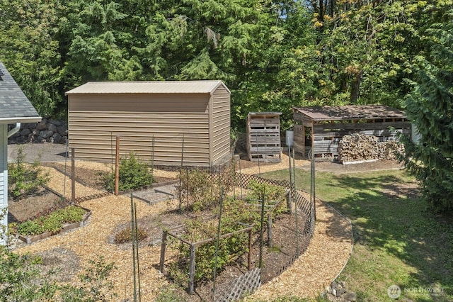 view of yard with an outdoor structure, a vegetable garden, and a storage unit