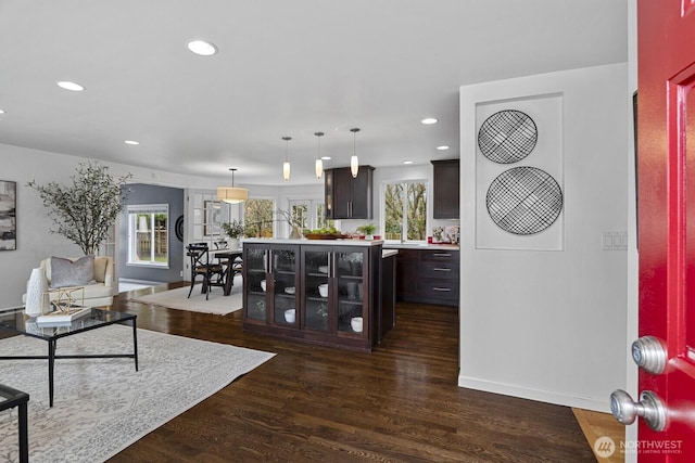 living area featuring plenty of natural light, recessed lighting, and dark wood-type flooring