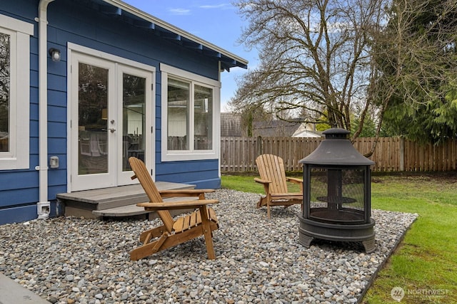 view of patio / terrace featuring french doors, a fire pit, and fence