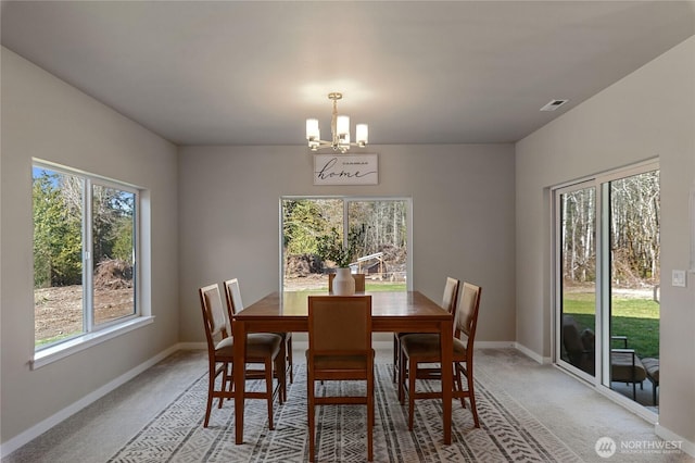 dining area featuring a chandelier, visible vents, light carpet, and baseboards