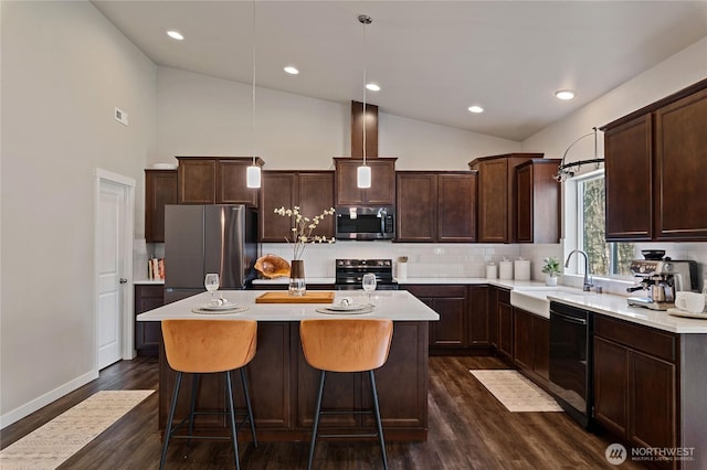 kitchen with lofted ceiling, appliances with stainless steel finishes, dark brown cabinets, and a sink