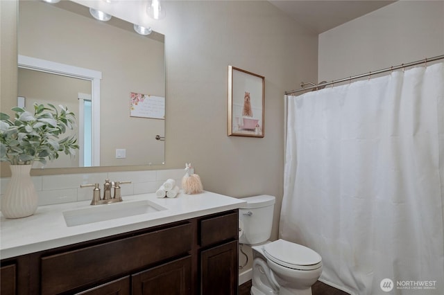 full bathroom with curtained shower, vanity, and toilet