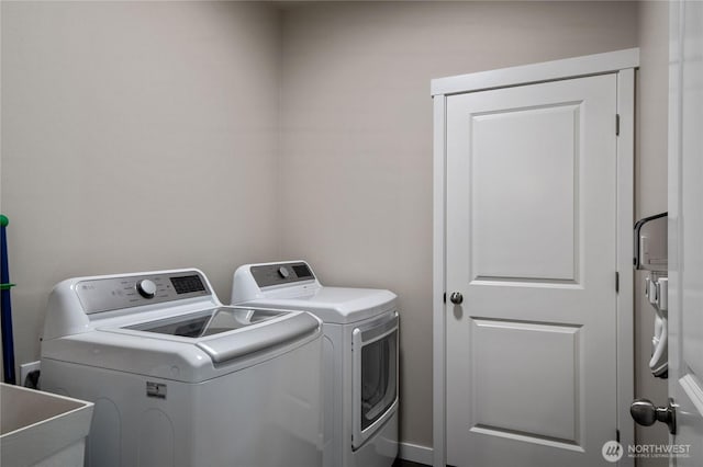 clothes washing area featuring laundry area, a sink, and separate washer and dryer