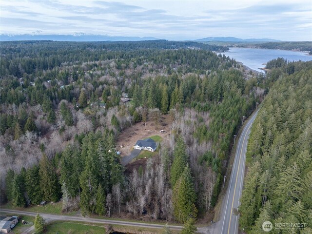 drone / aerial view with a forest view and a water view