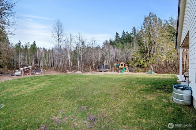 view of yard with a playground and a view of trees