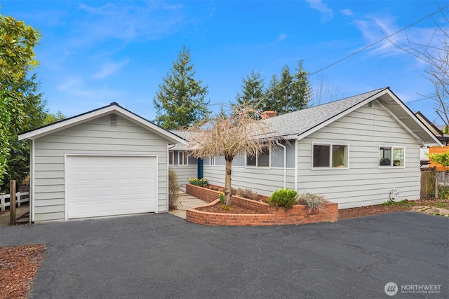 ranch-style home with aphalt driveway, fence, roof with shingles, a garage, and a chimney