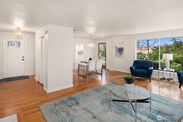 living room featuring baseboards, an inviting chandelier, and wood finished floors