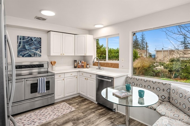 kitchen with a sink, visible vents, appliances with stainless steel finishes, and white cabinets